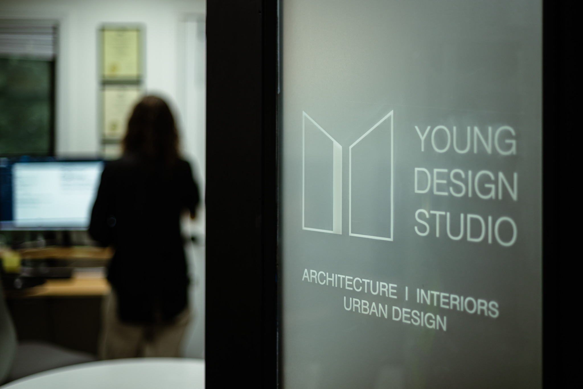 Young Design Studio office with studio signage and a team member at work