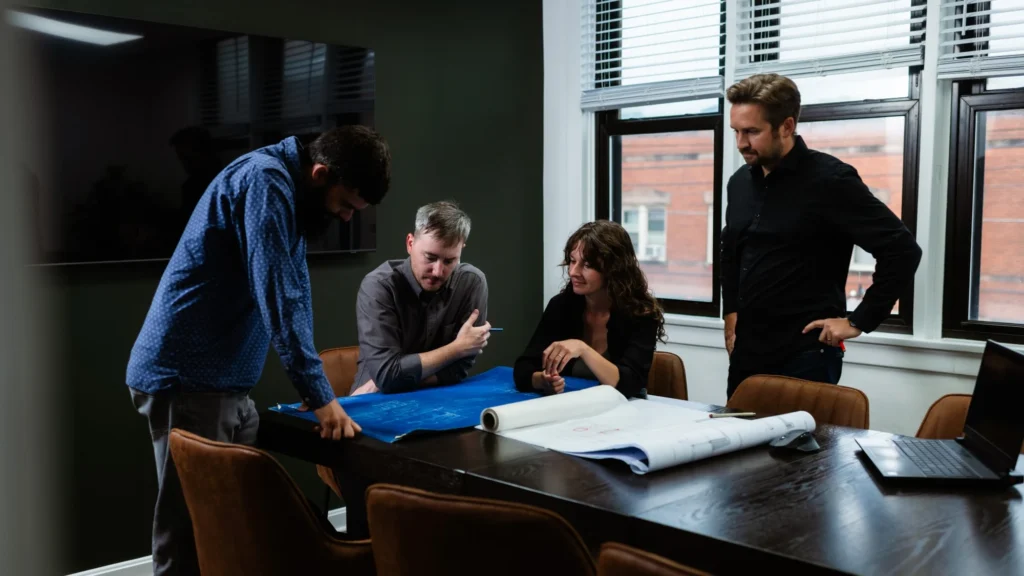 The studio team collaborating around architectural plans